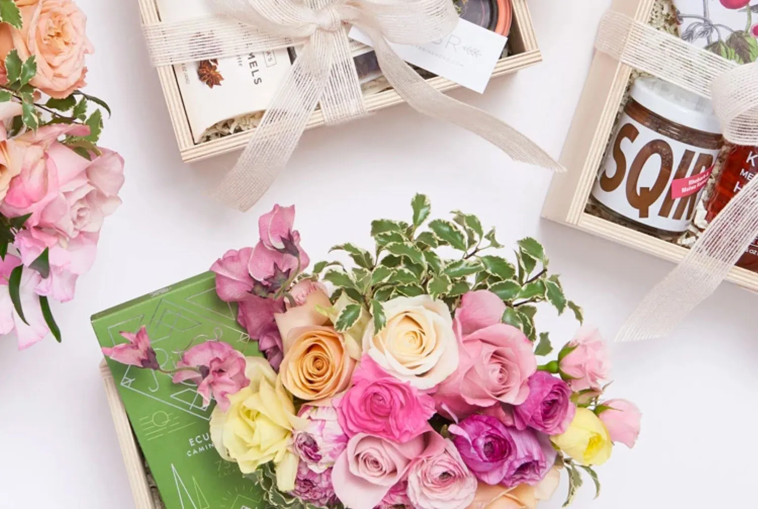 Flowers, roses, and gift boxes arranged on a white table
